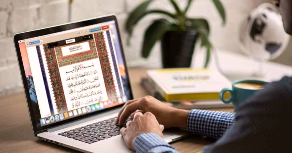 Illustration of a laptop displaying a Quranic verse with a teacher and student engaging in an online class