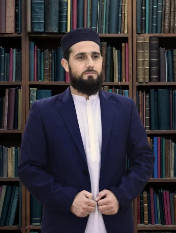 Ijazah certified Quran tutor in traditional attire standing in library with Islamic books